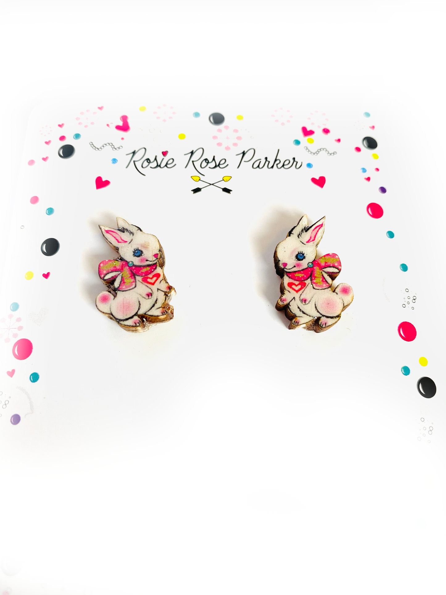 Little white bunnies with ribbon studs, made from wood and resin.