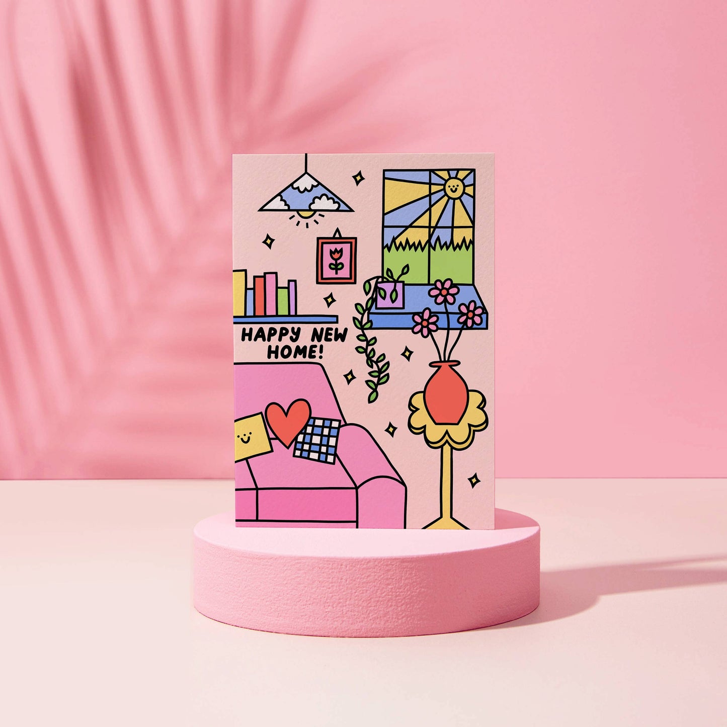 Happy new home.   A bright pink, blue, yellow home interior with flowers, books and a cosy sofa.