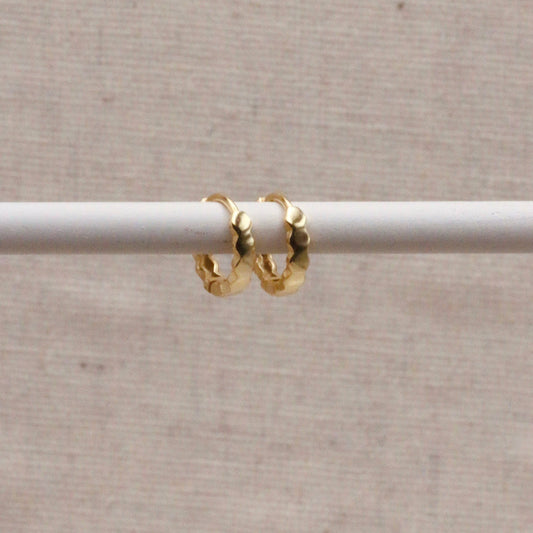 Gold scalloped edged huggy earrings.
