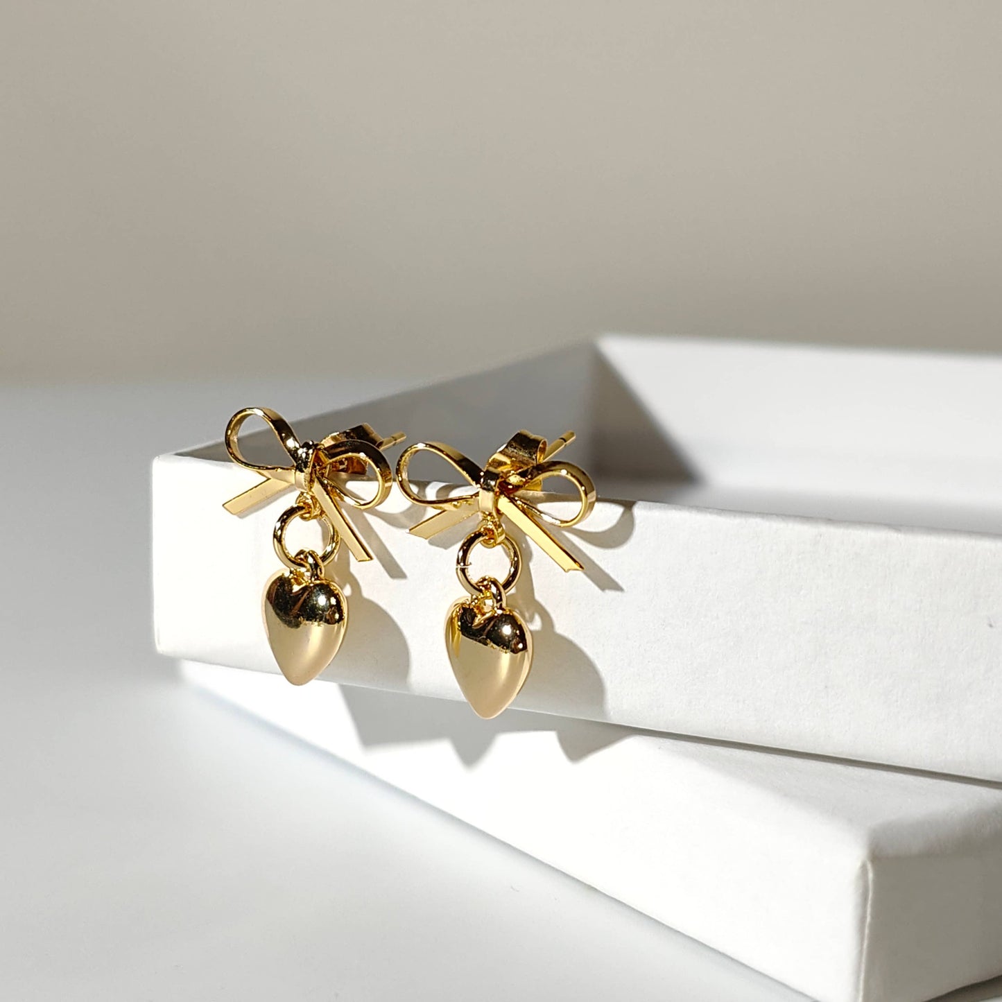 Gold plate bow with dangling heart