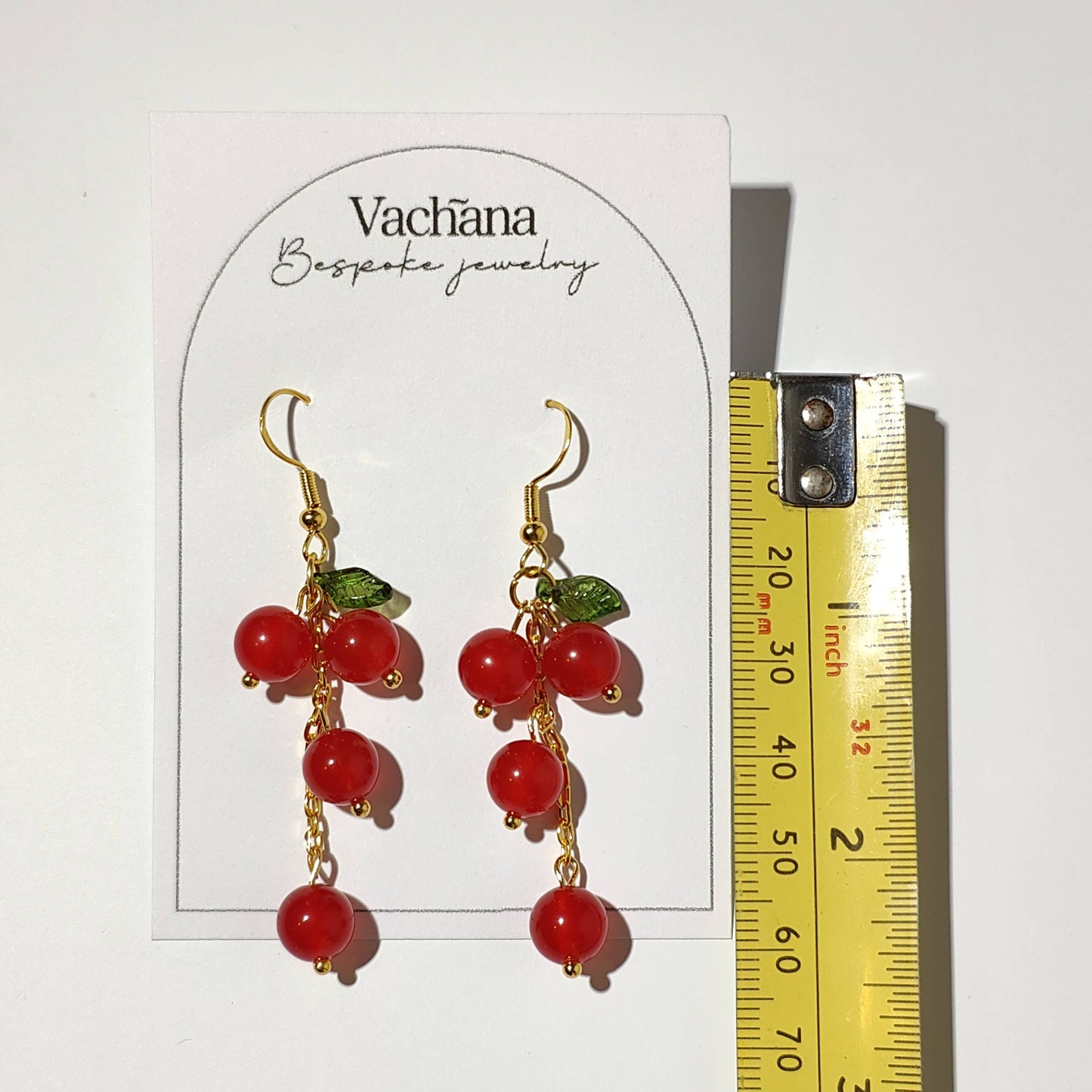 Cascade of red cherry gem stones with acrylic leaf on gold plated hooks