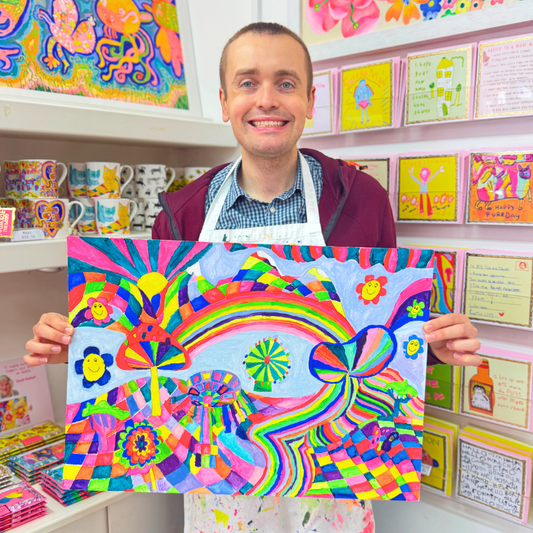 Man holding a colorful abstract painting in a store setting