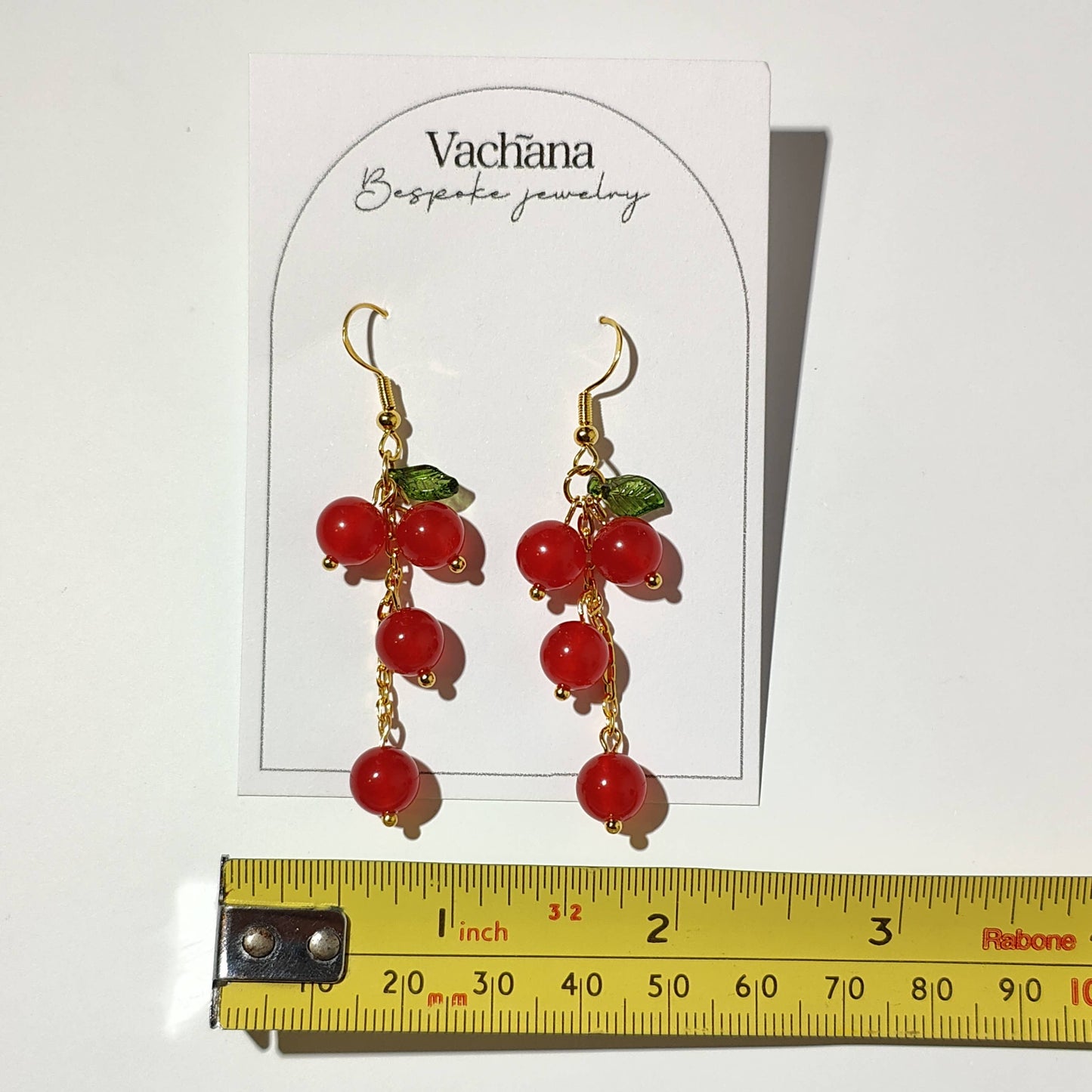 Cascade of red cherry gem stones with acrylic leaf on gold plated hooks
