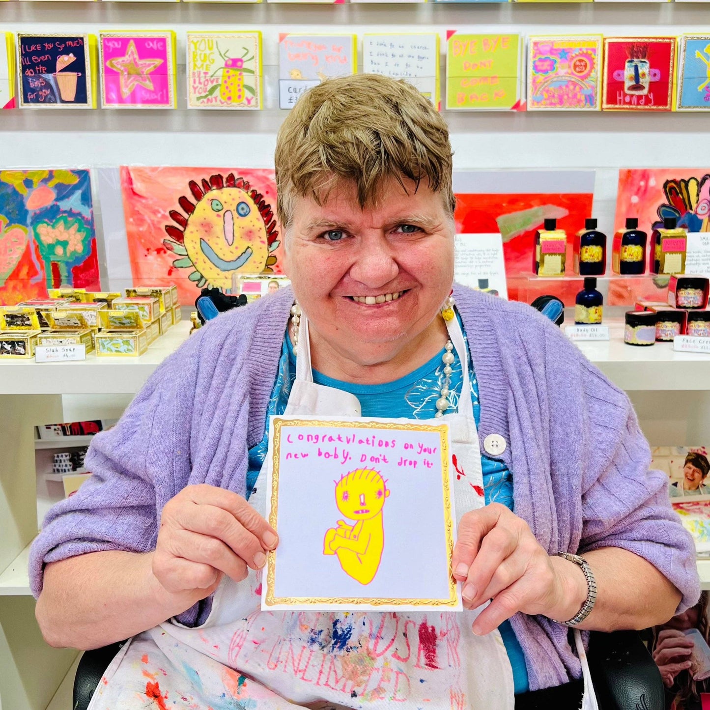 Person holding a card with a yellow creature design in a craft store setting