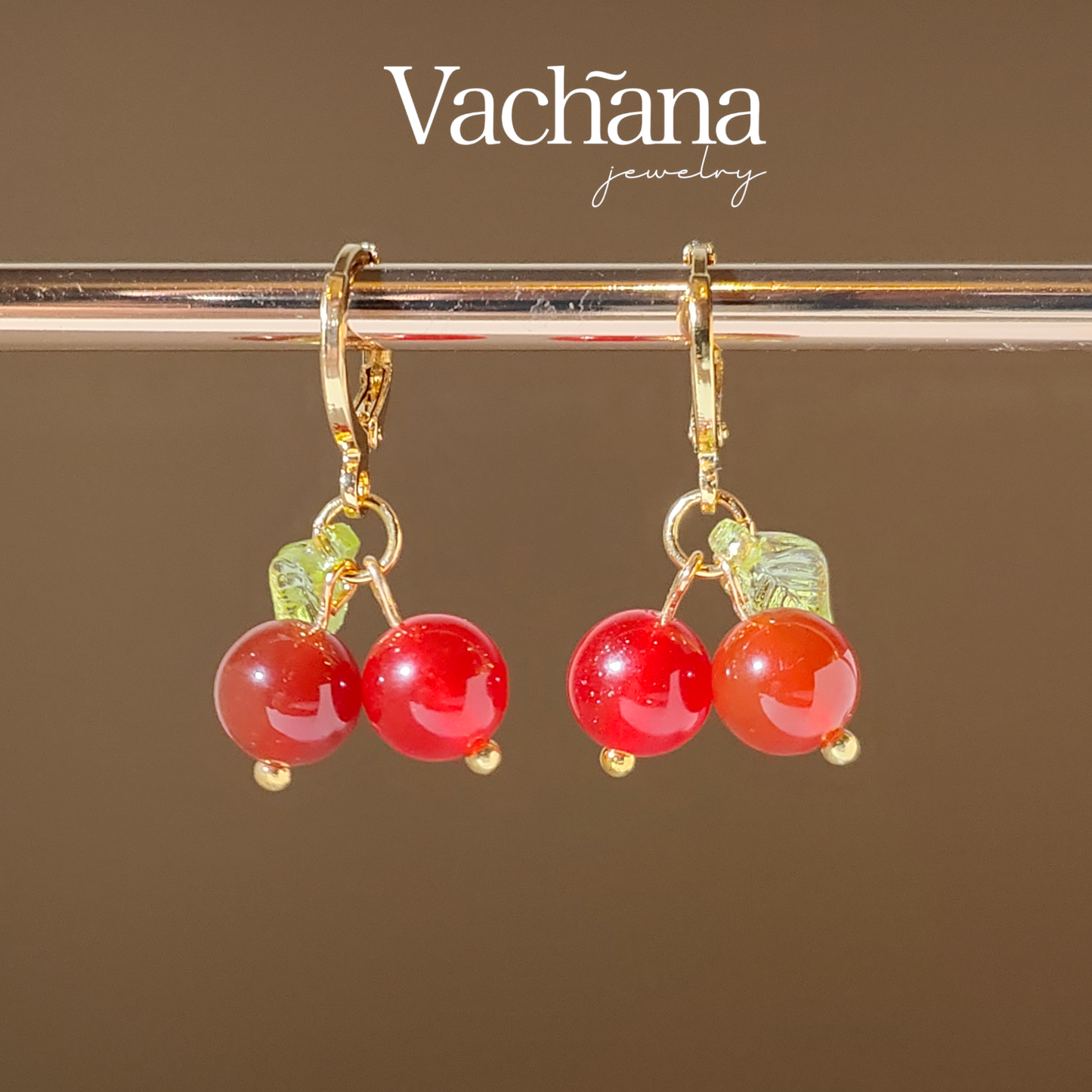 Semi precious stone cherry charms hanging on gold plated hoops.