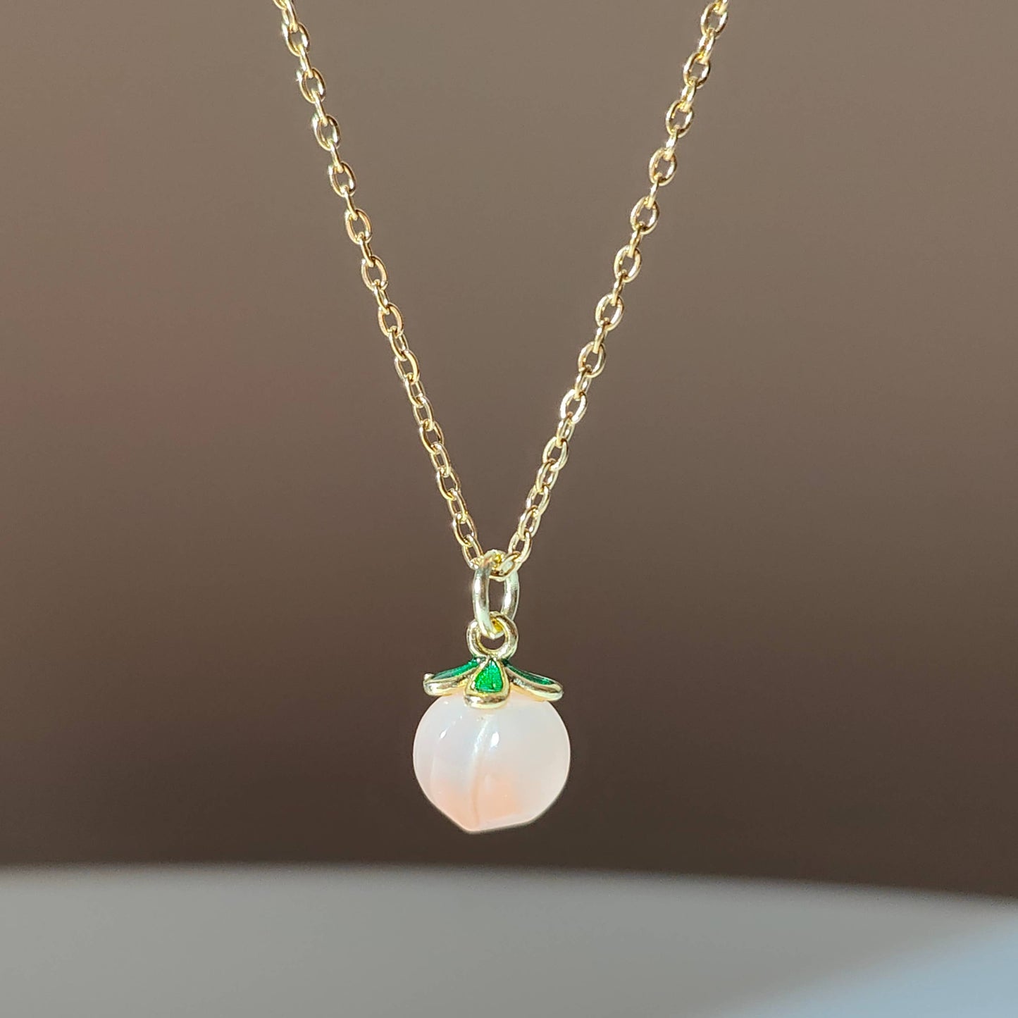a natural yuan yan stone on a gold plate chain.
