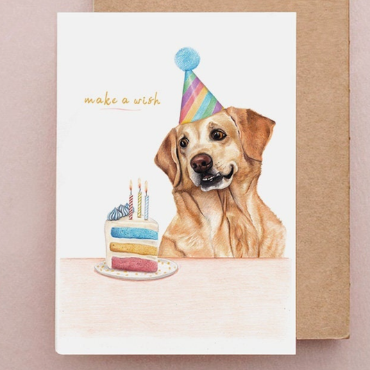Birthday card with a dog wearing a party hat and a cake, on a pink background.