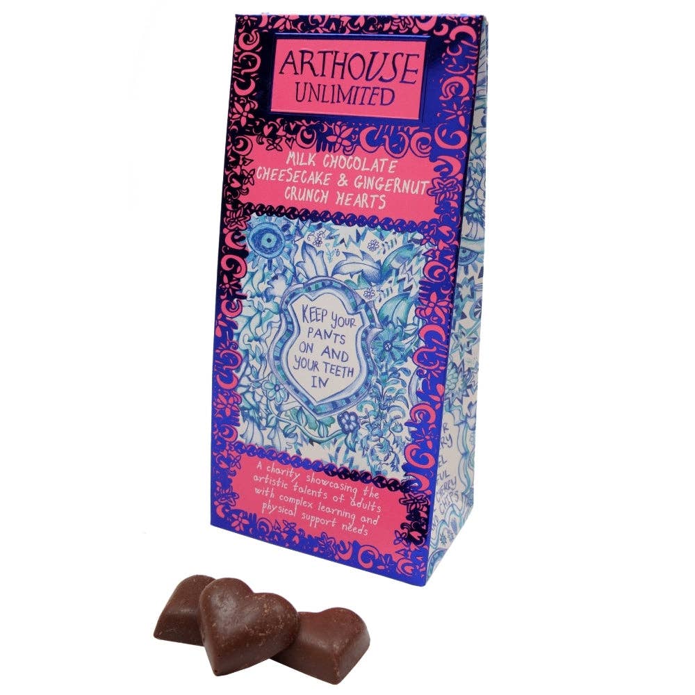 A tall decorative chocolate box from Arthouse Unlimited with pink, blue, and purple ornate graphics, shown on a white background with three heart-shaped milk chocolate pieces in front.