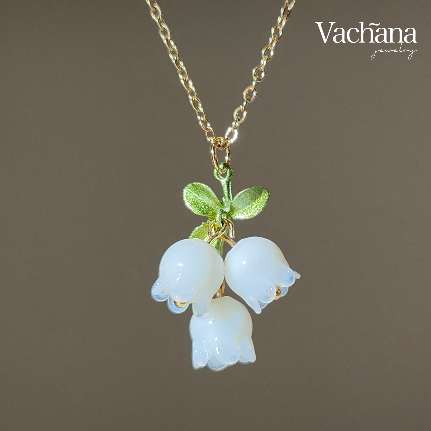 Glass lily of the valley charm hanging on gold plated chain.