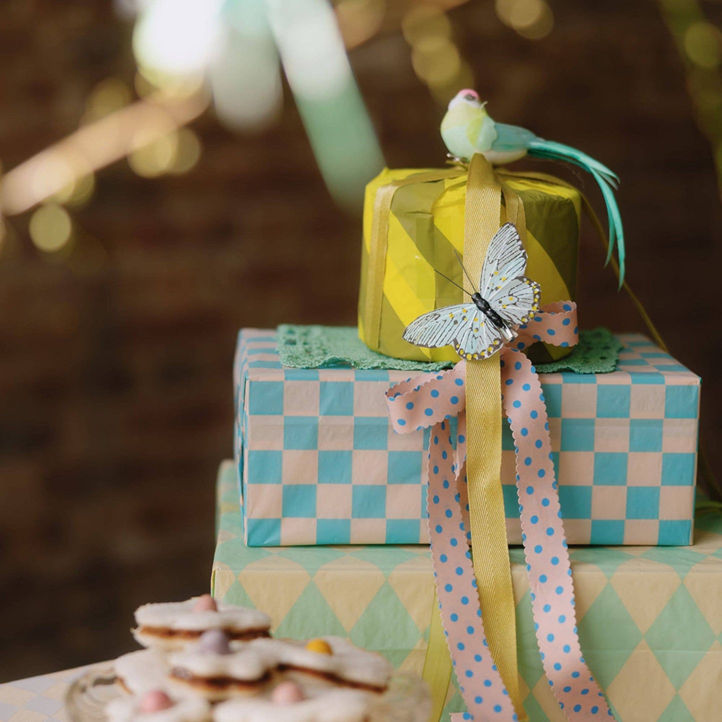 Decorative gift boxes with ribbons and a bird figurine on a blurred background