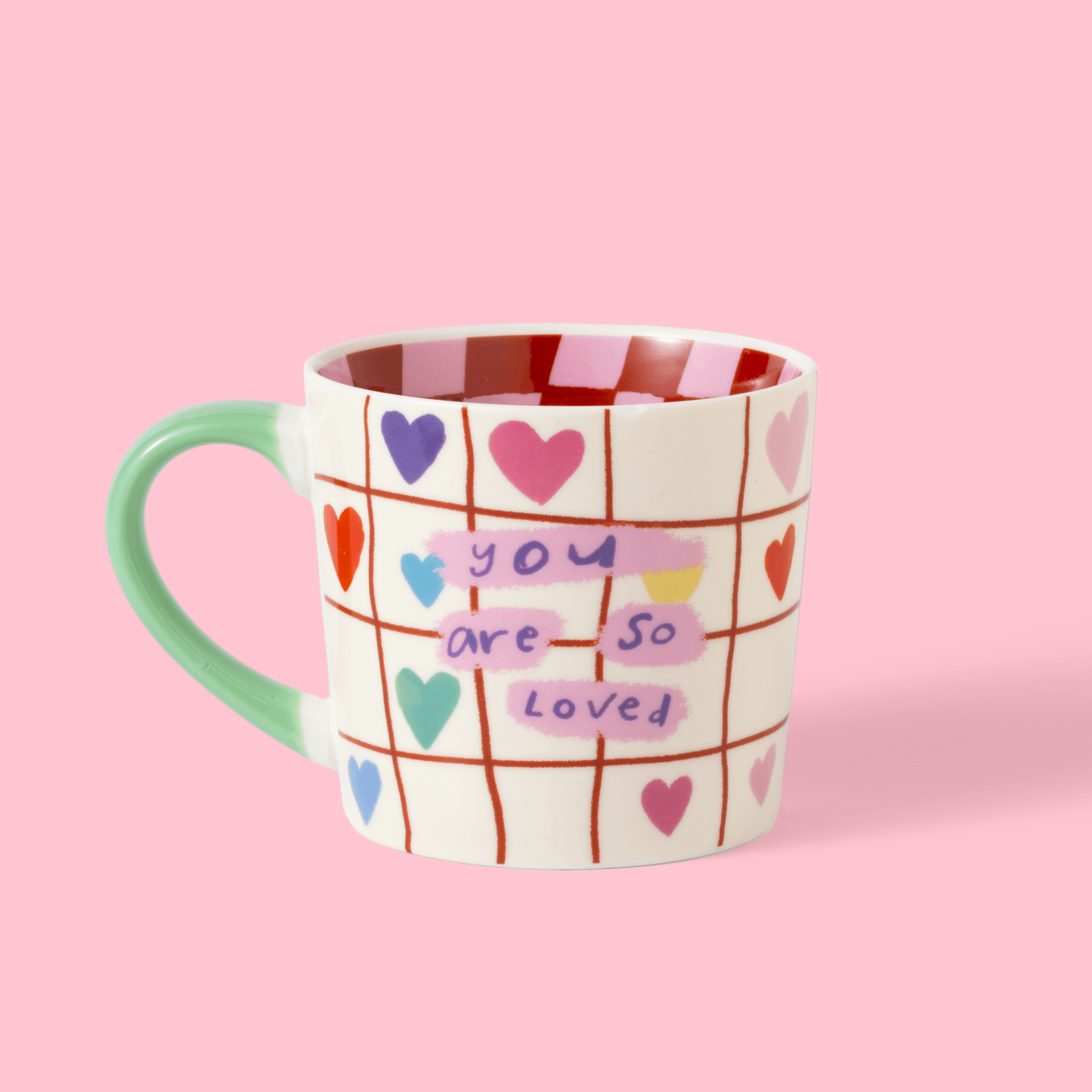 Mug with heart designs and text on a pink background