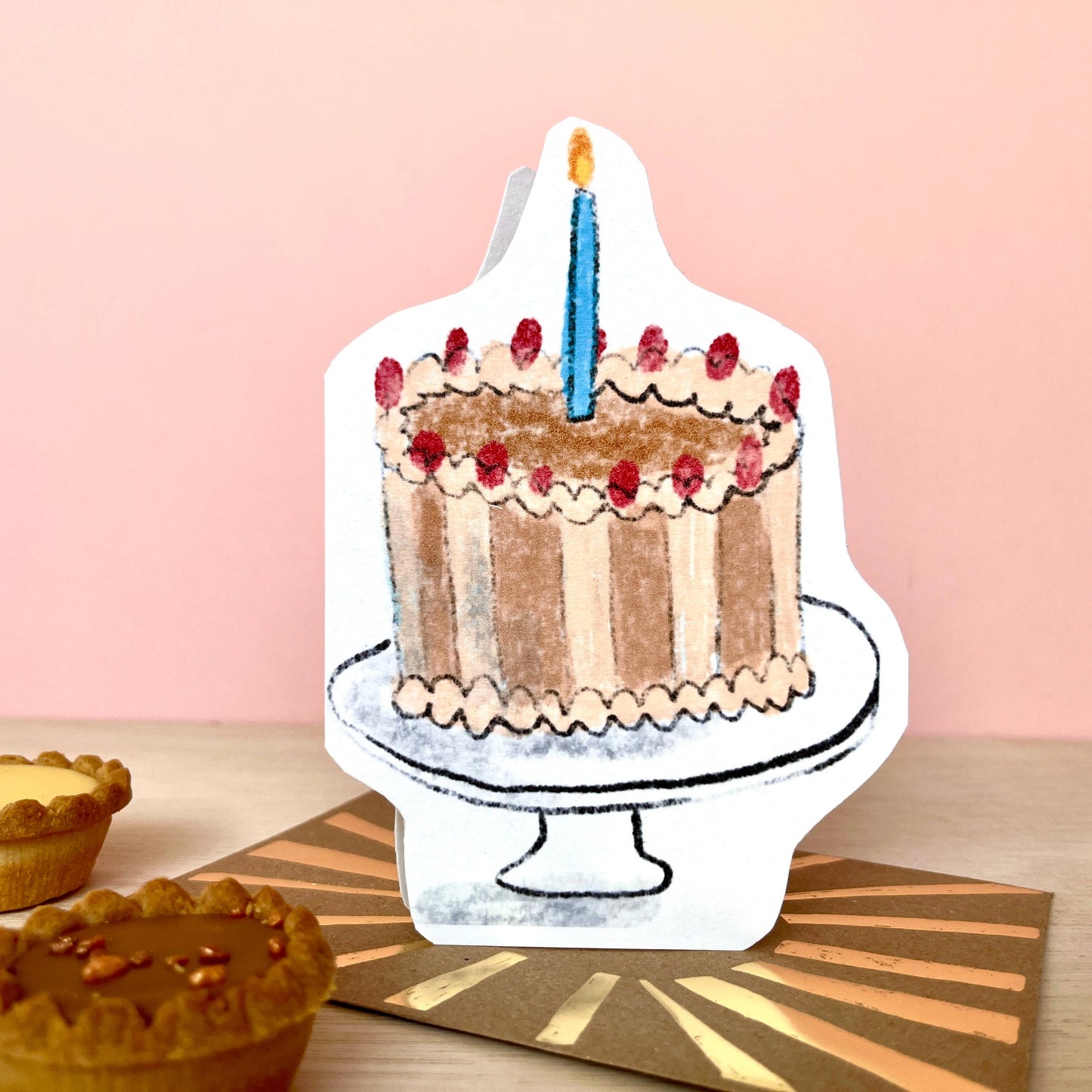 Chocolate cake with one candle, card in the shape of the cake.