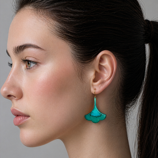 Close-up of a woman wearing a turquoise earring against a neutral background