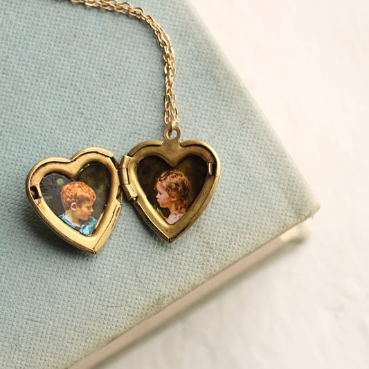 Heart-shaped locket with portraits on a light blue fabric background