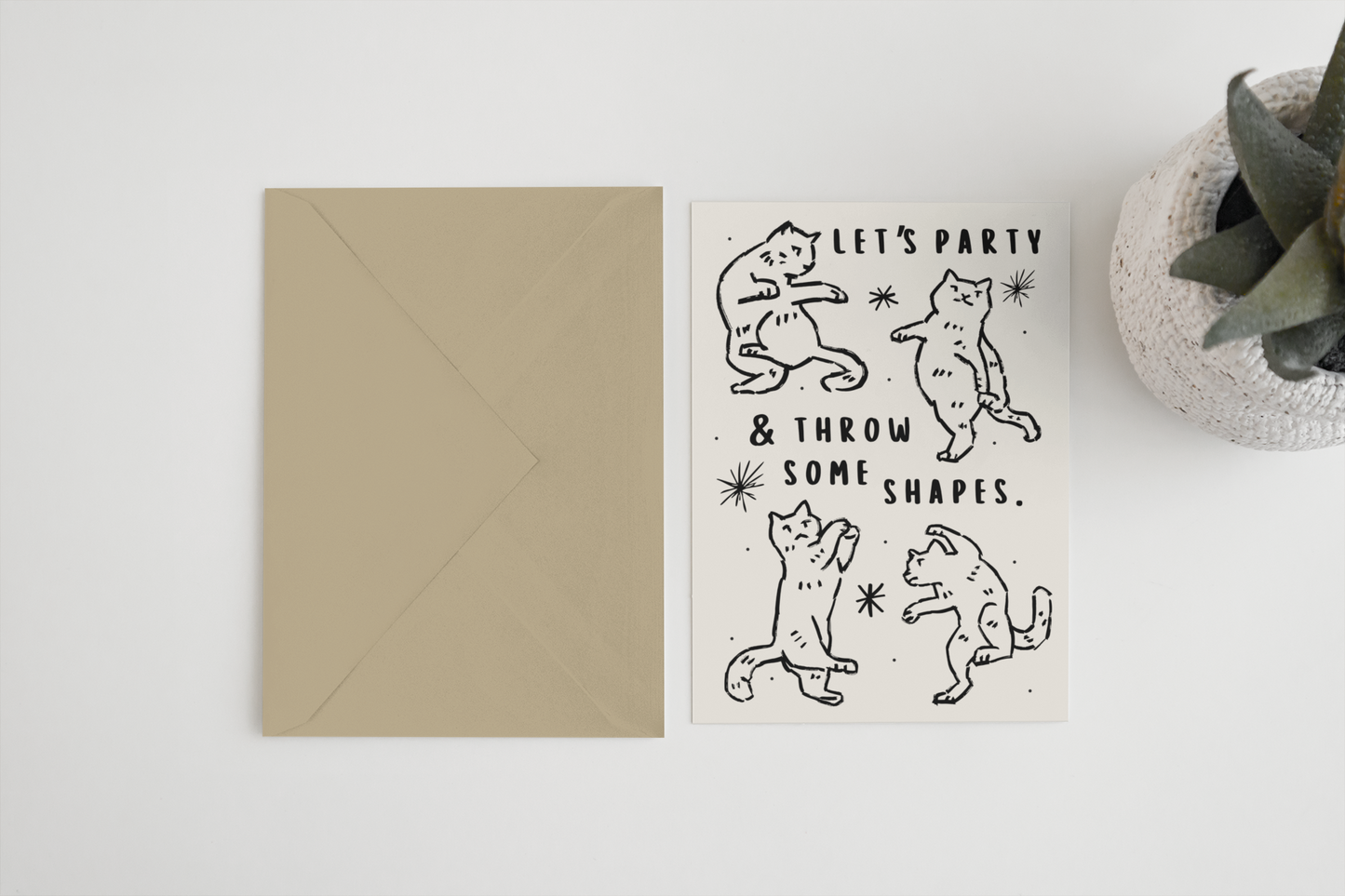 Greeting card with bear illustrations and text 'Let's party & throw some shapes' on a white surface.