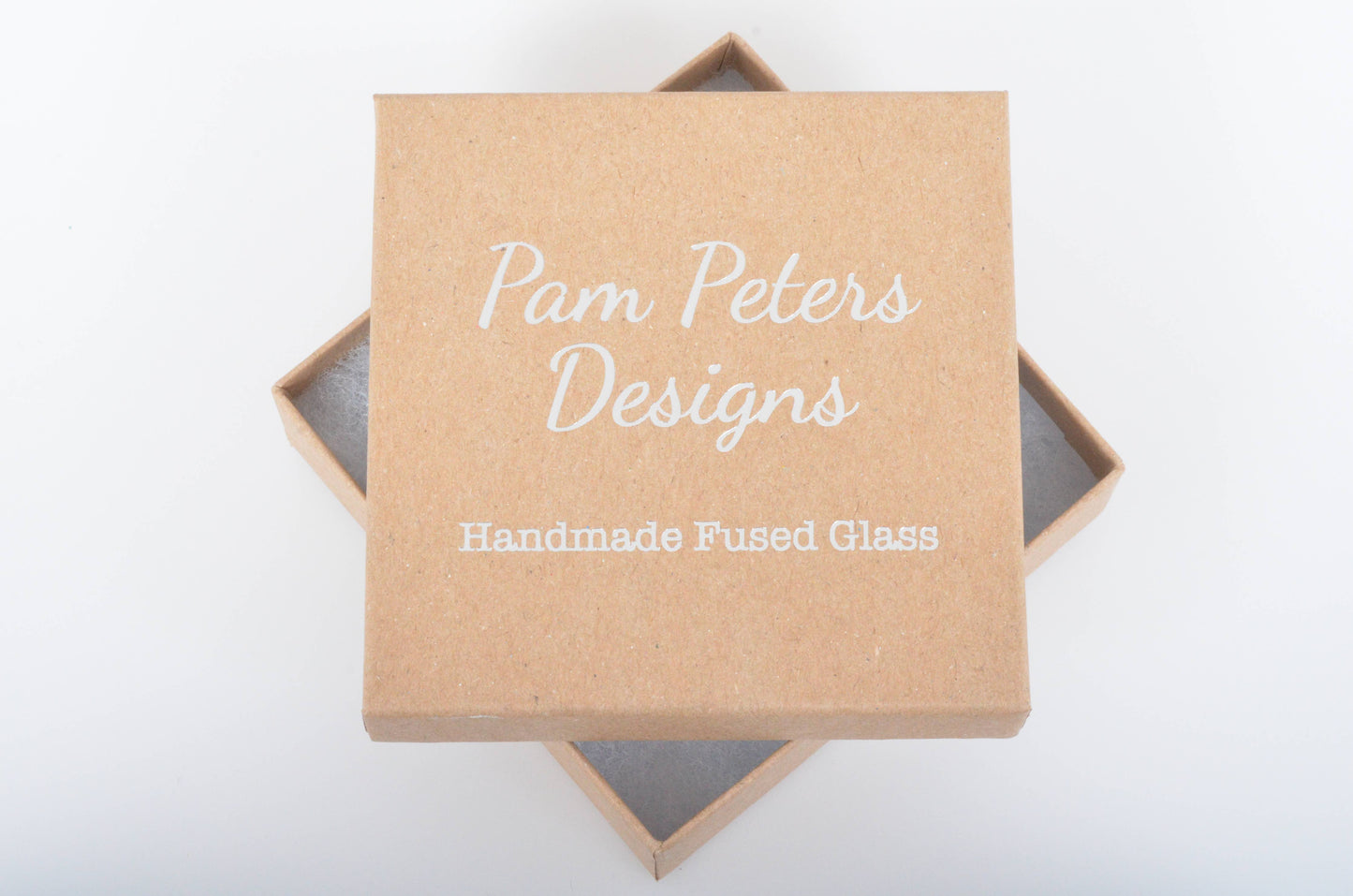 Kraft paper box with 'Pam Peters Designs' branding on a white background