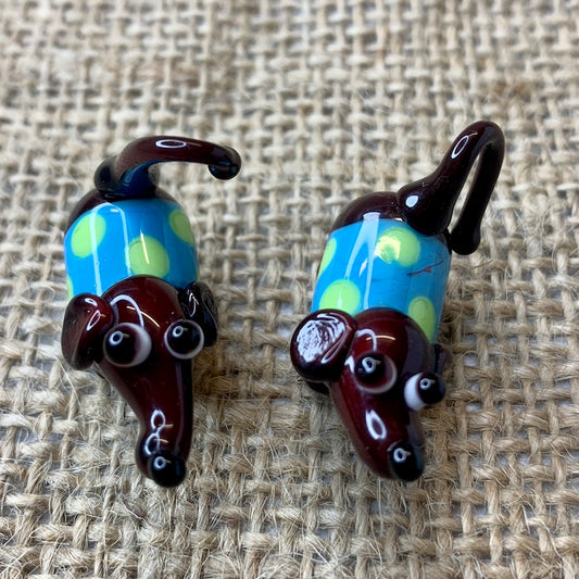 Friend in a box tiny glass brown dog with a spotty coat with spots.