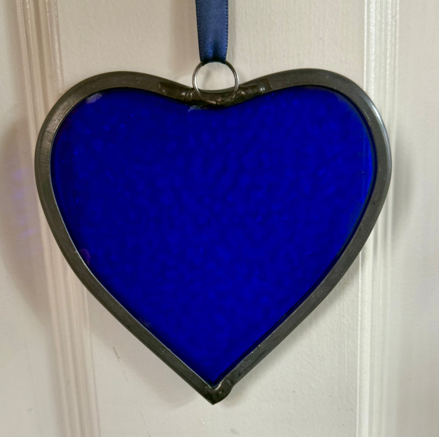 A medium sized Glass heart with a lead edging and a copper wire hook to hang in a window or outside in a tree
