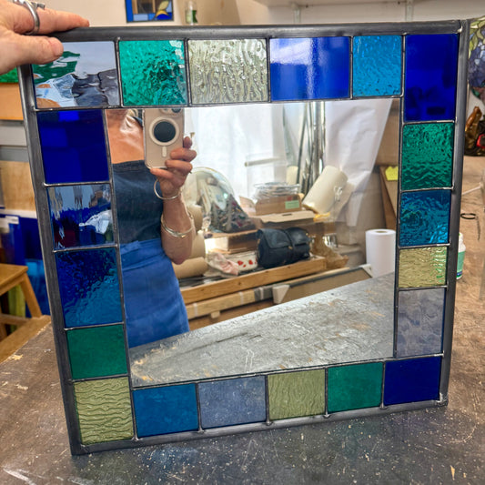 Square stained glass mirror with a 6cm border of greens, blues and aqua colours.