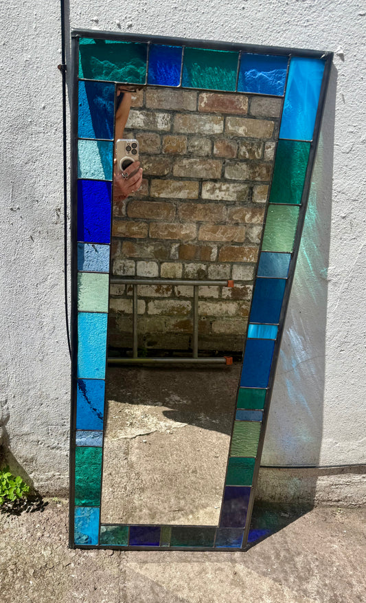 Full length stained glass mirror with a 6cm geometric border of blues, greens and aqua colours.