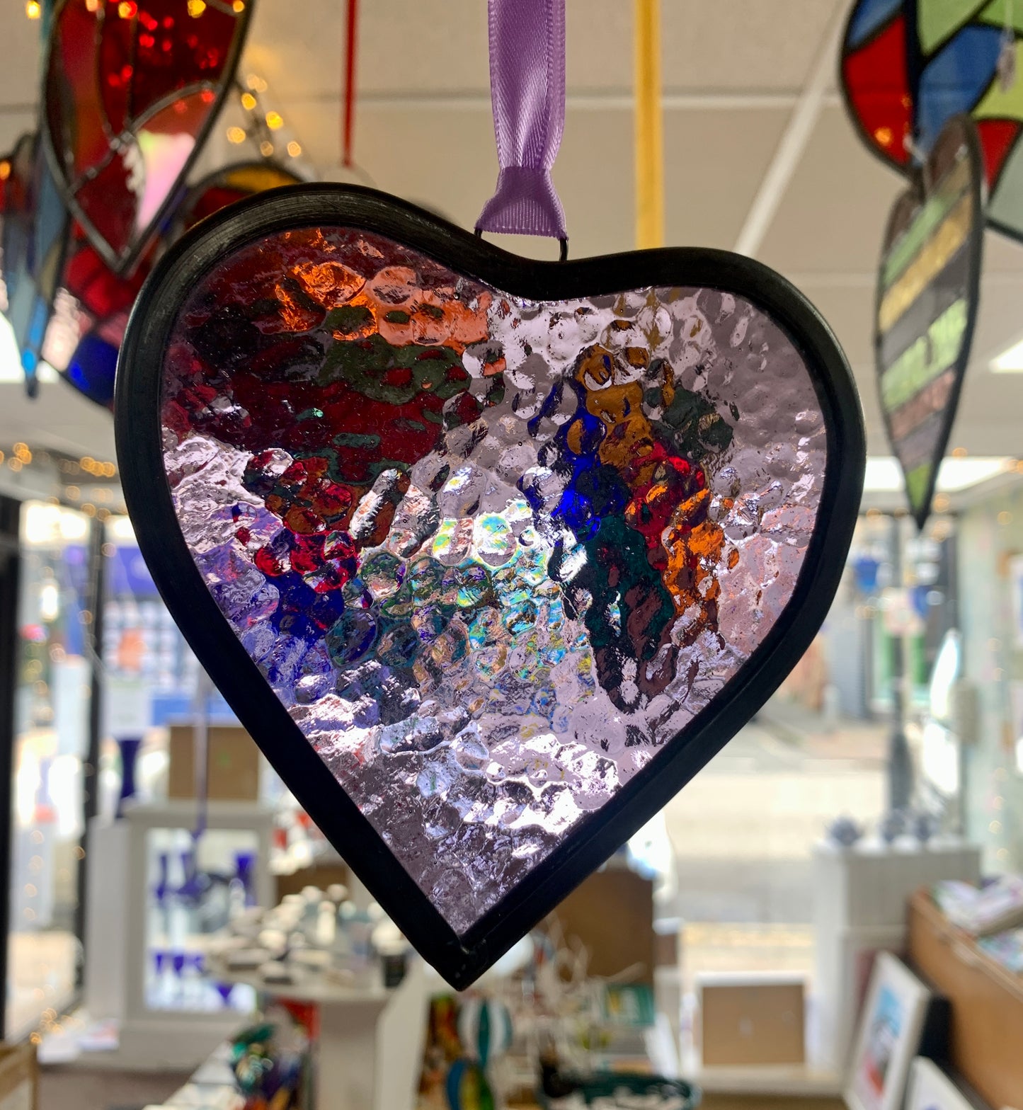 A medium sized Glass heart with a lead edging and a copper wire hook to hang in a window or outside in a tree