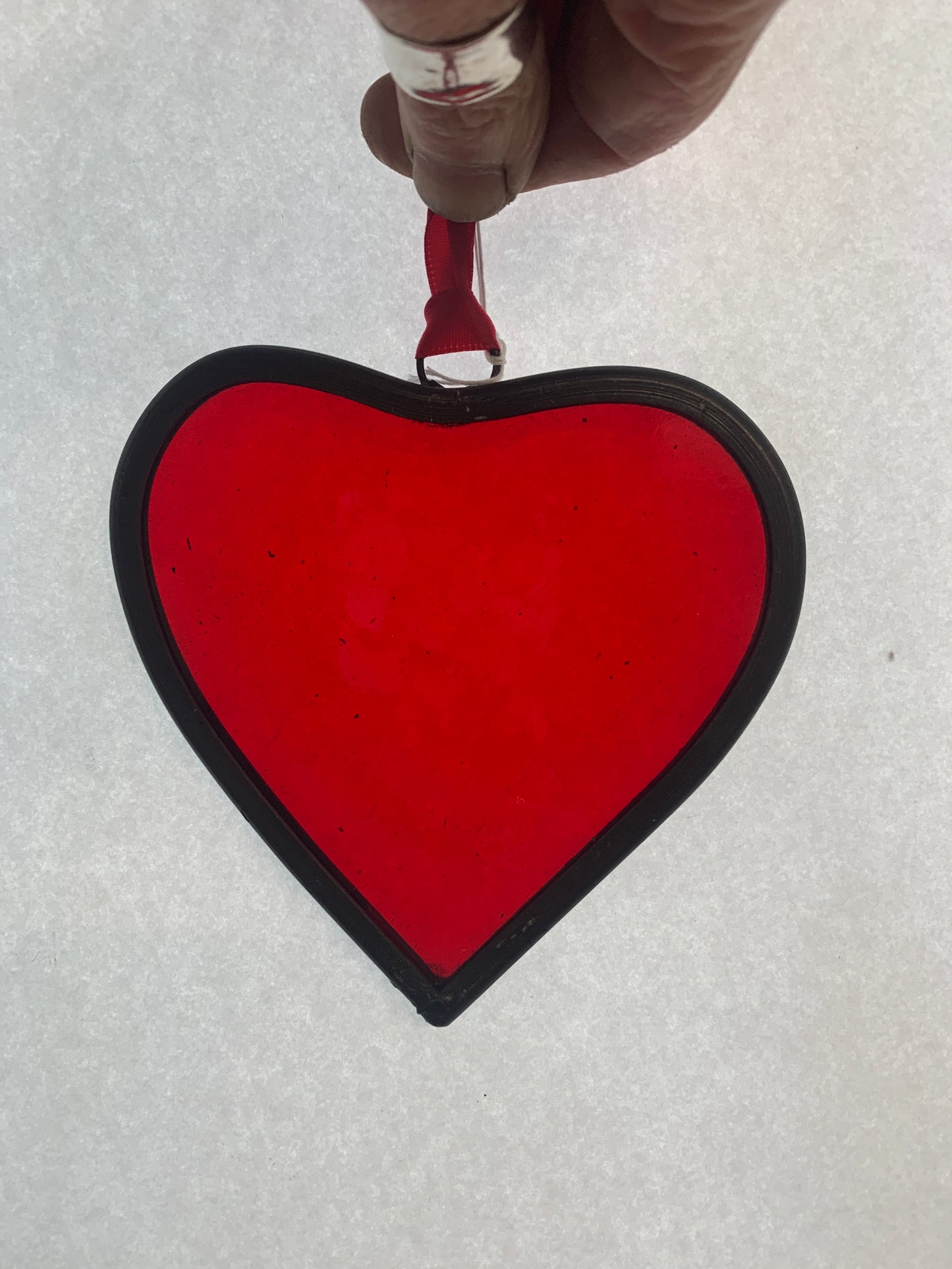 A medium sized Glass heart with a lead edging and a copper wire hook to hang in a window or outside in a tree