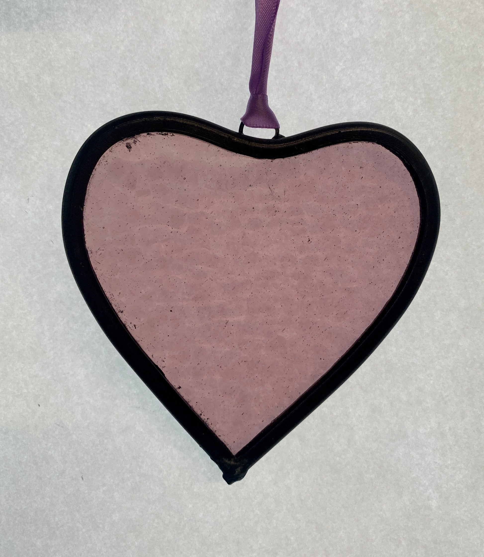 A medium sized Glass heart with a lead edging and a copper wire hook to hang in a window or outside in a tree