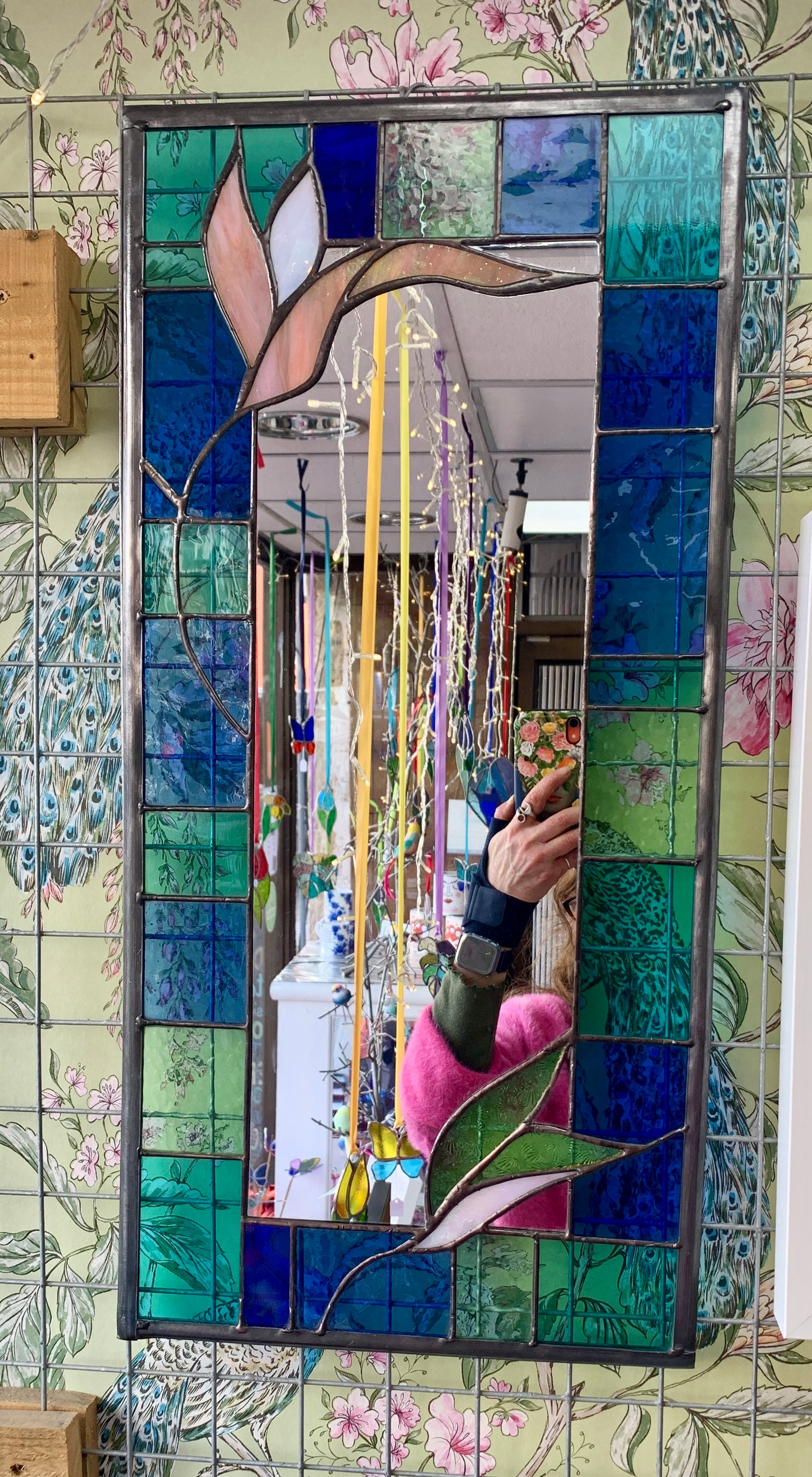Stained Glass Mirror. Blue and Turquoise border glass; Irridiscent glass floral petals. Made by Dadswell Glass.