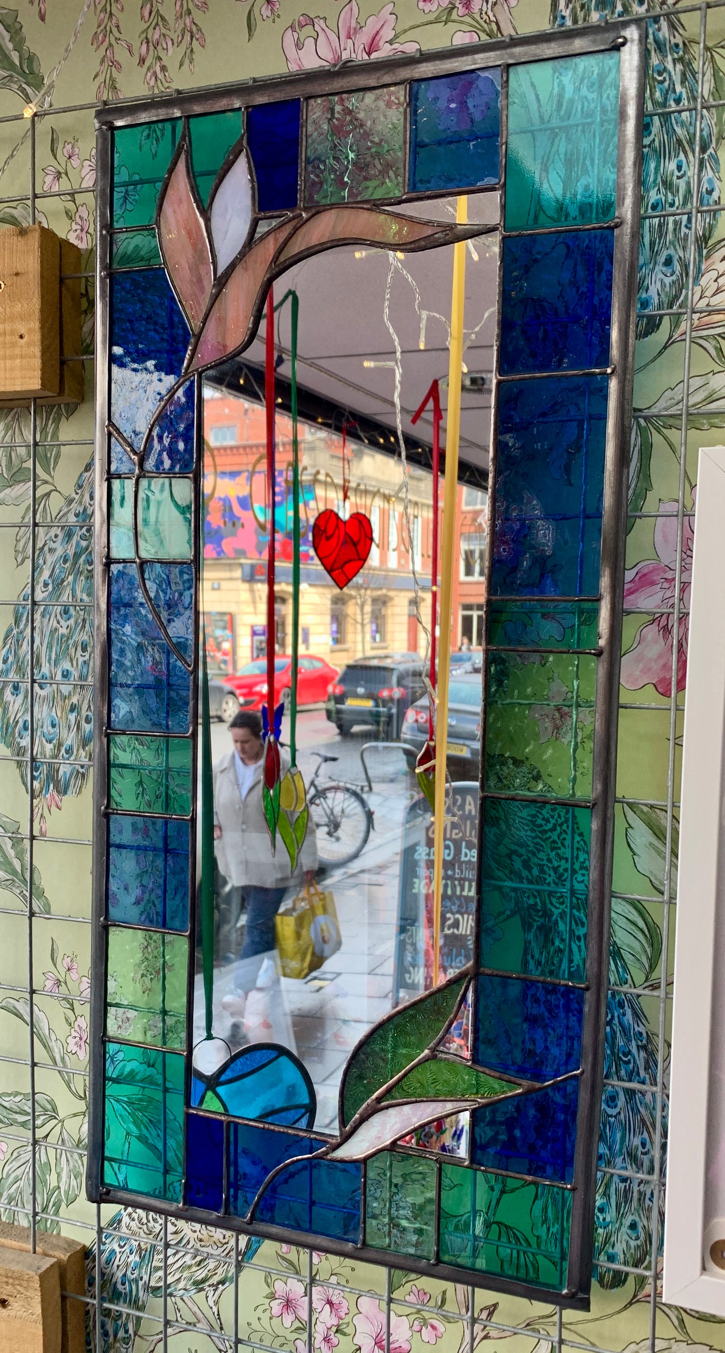 Stained Glass Mirror. Blue and Turquoise border glass; Irridiscent glass floral petals. Made by Dadswell Glass.