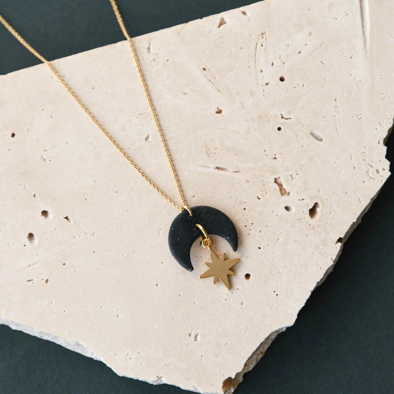 Gold chain necklace with black crescent moon and gold star