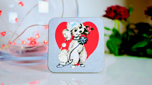 Coaster with a dog illustration on a red heart background, placed on a surface with decorative elements.