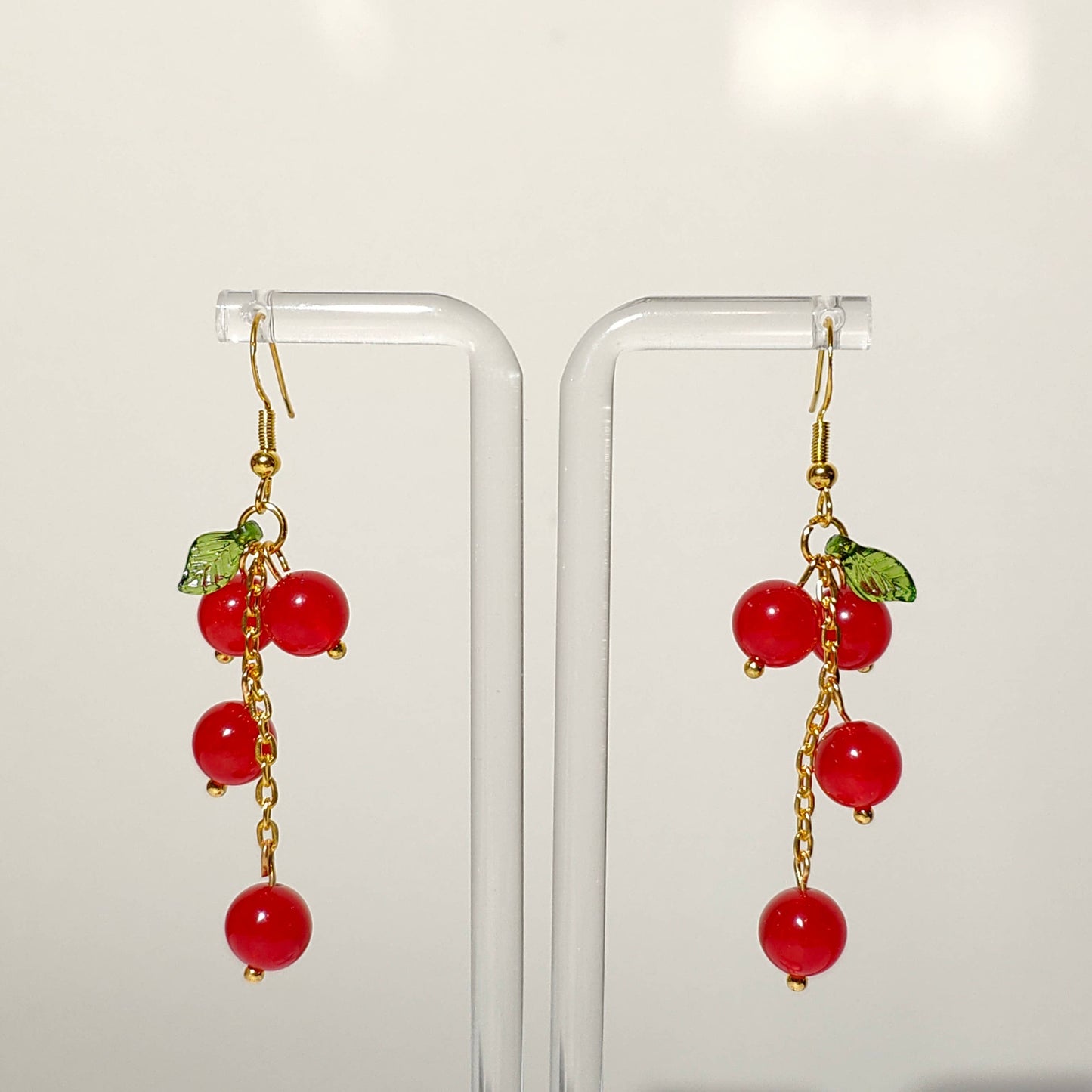 Cascade of red cherry gem stones with acrylic leaf on gold plated hooks
