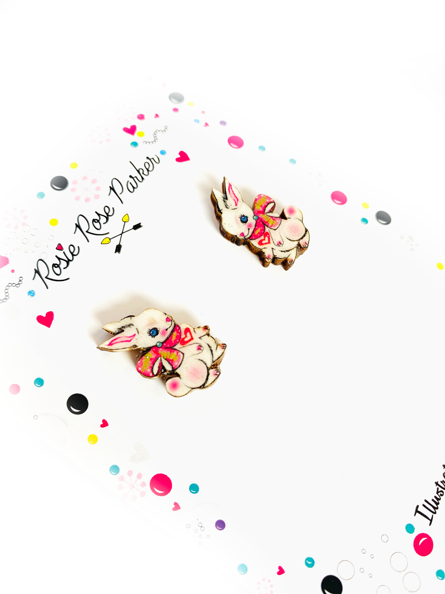 Little white bunnies with ribbon studs, made from wood and resin.