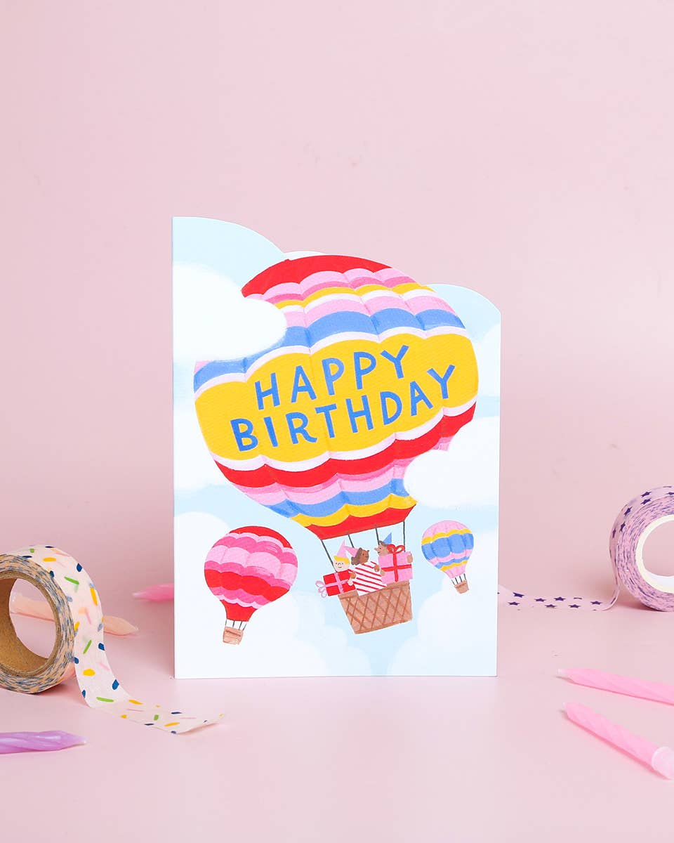 Birthday card with hot air balloons and 'Happy Birthday' text on a pink background