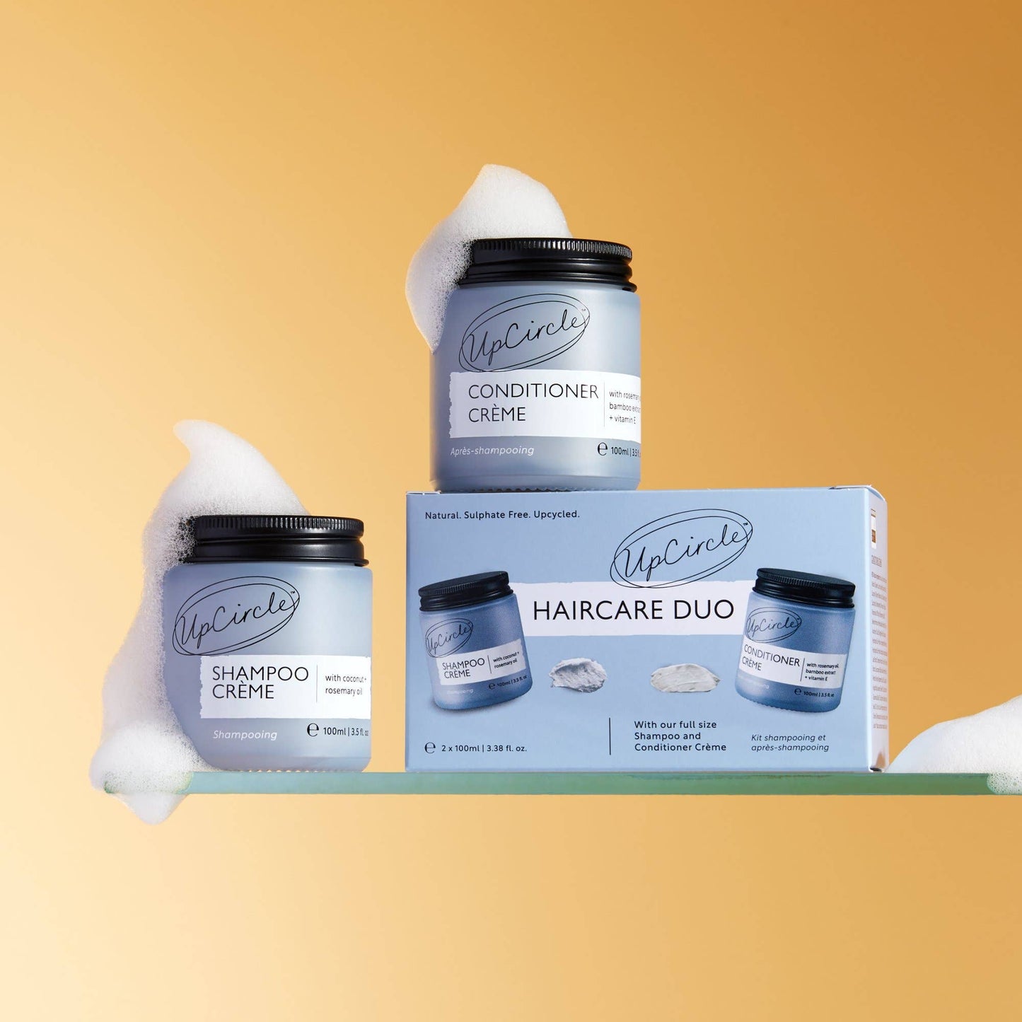 UpCircle haircare products including shampoo and conditioner crème with packaging on a yellow background