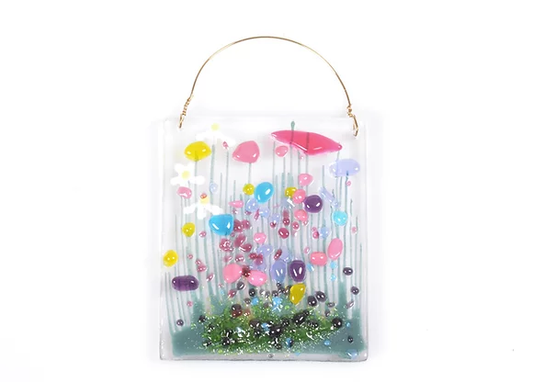 handmade fused glass hanging token with floral motif.