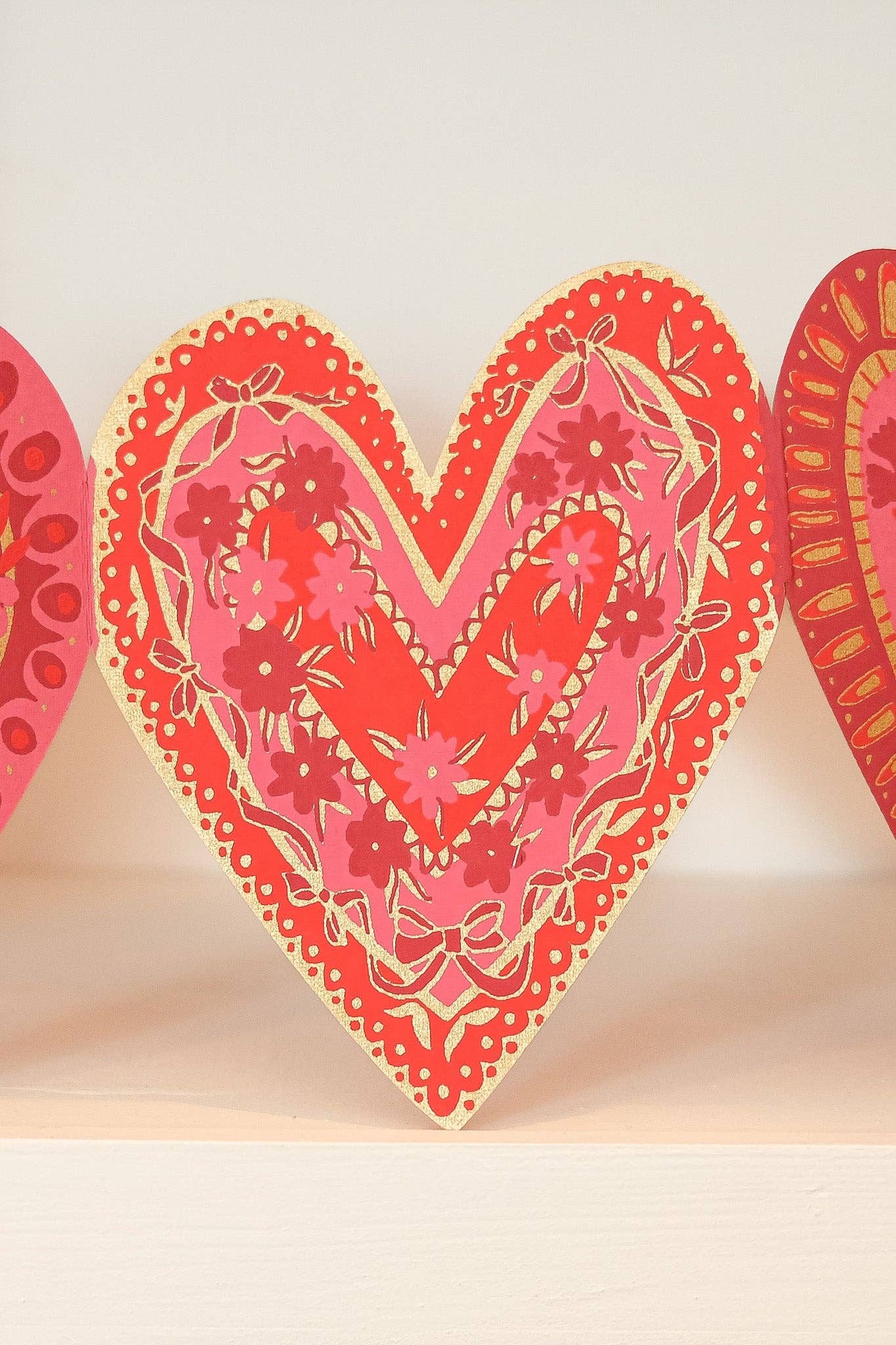 Decorative heart-shaped card with floral patterns on a beige background