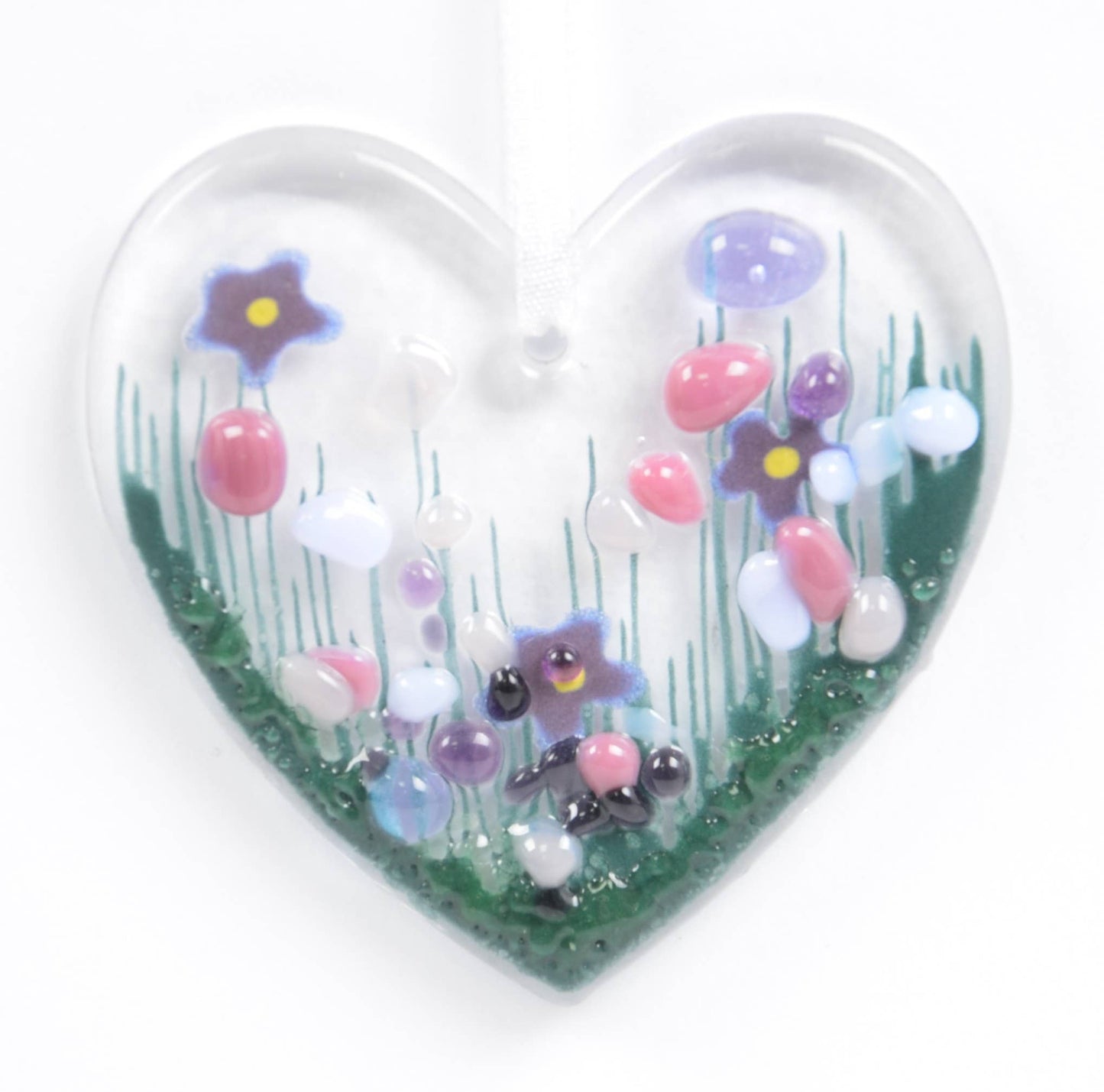 Heart-shaped glass ornament with colorful flowers on a white background