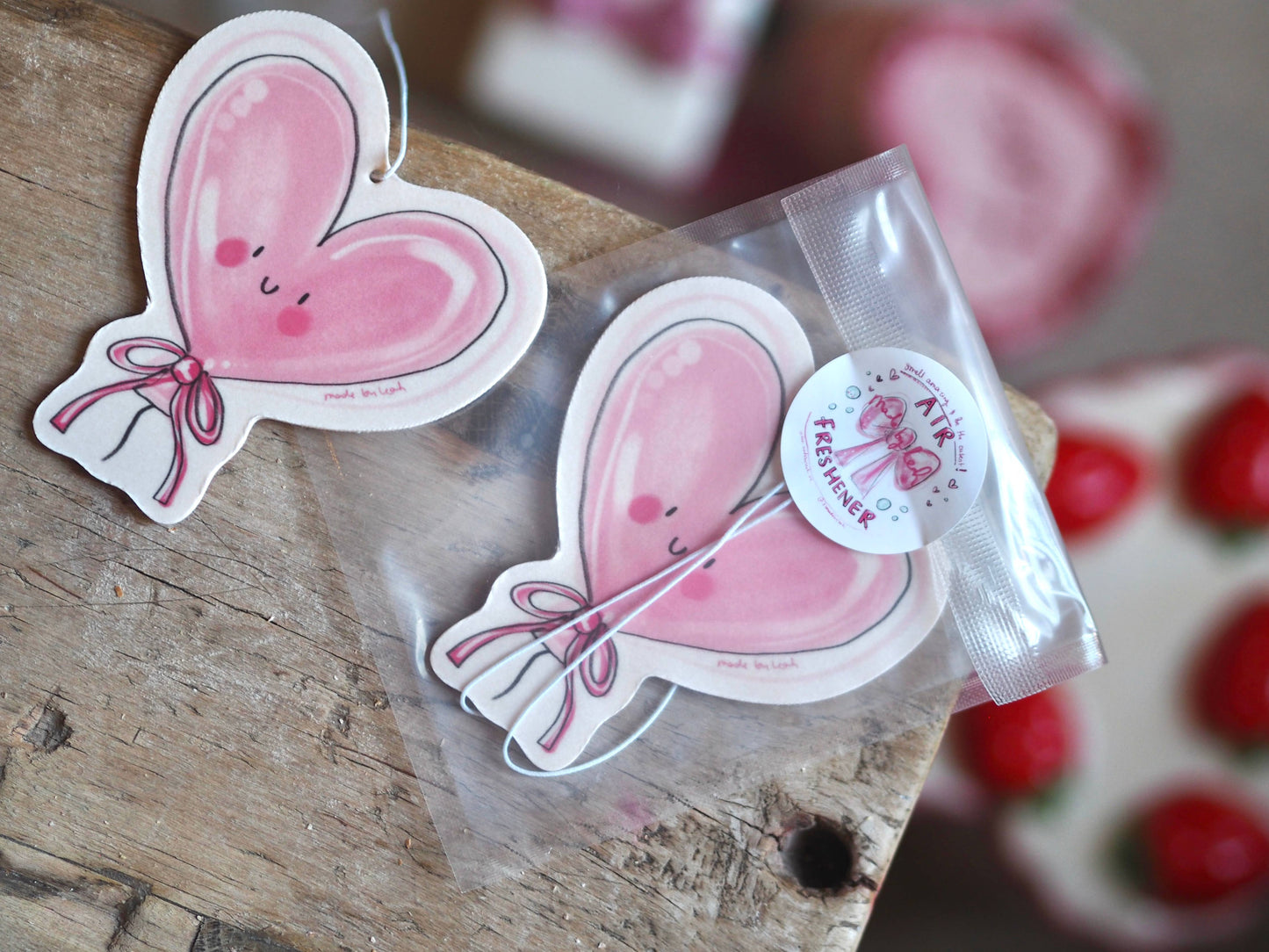 Heart-shaped pink stickers with a bow design on a wooden surface.