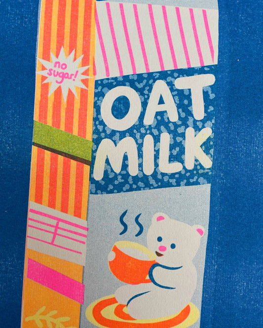 Carton of oat milk with colorful design and cartoon bear illustration on a blue background