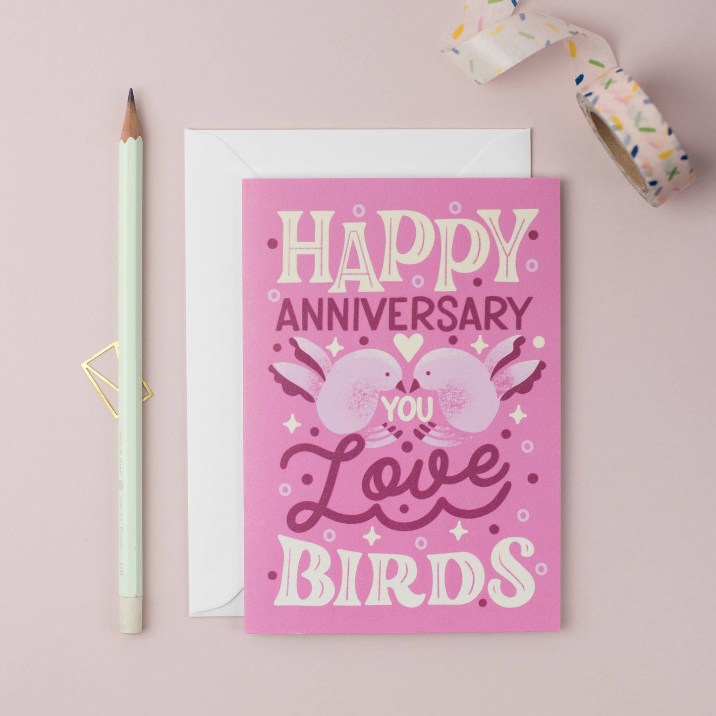 Pink anniversary card with birds and a pencil on a pink background