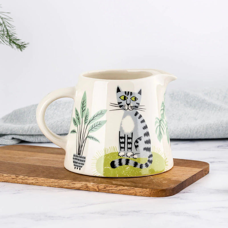 White ceramic milk jug with an original folk art style design of a cat.