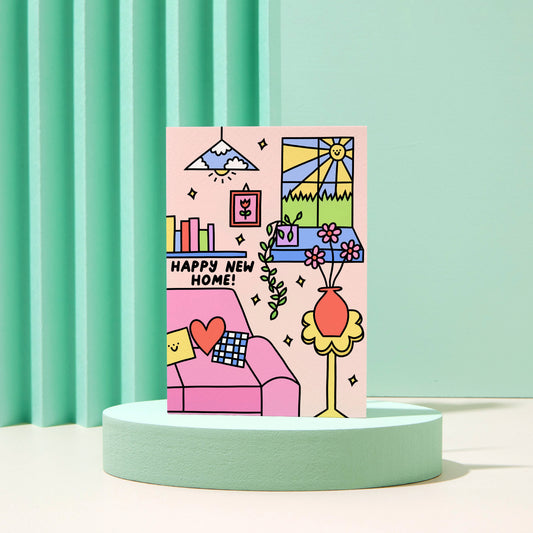 Happy new home. A bright pink, blue, yellow home interior with flowers, books and a cosy sofa.