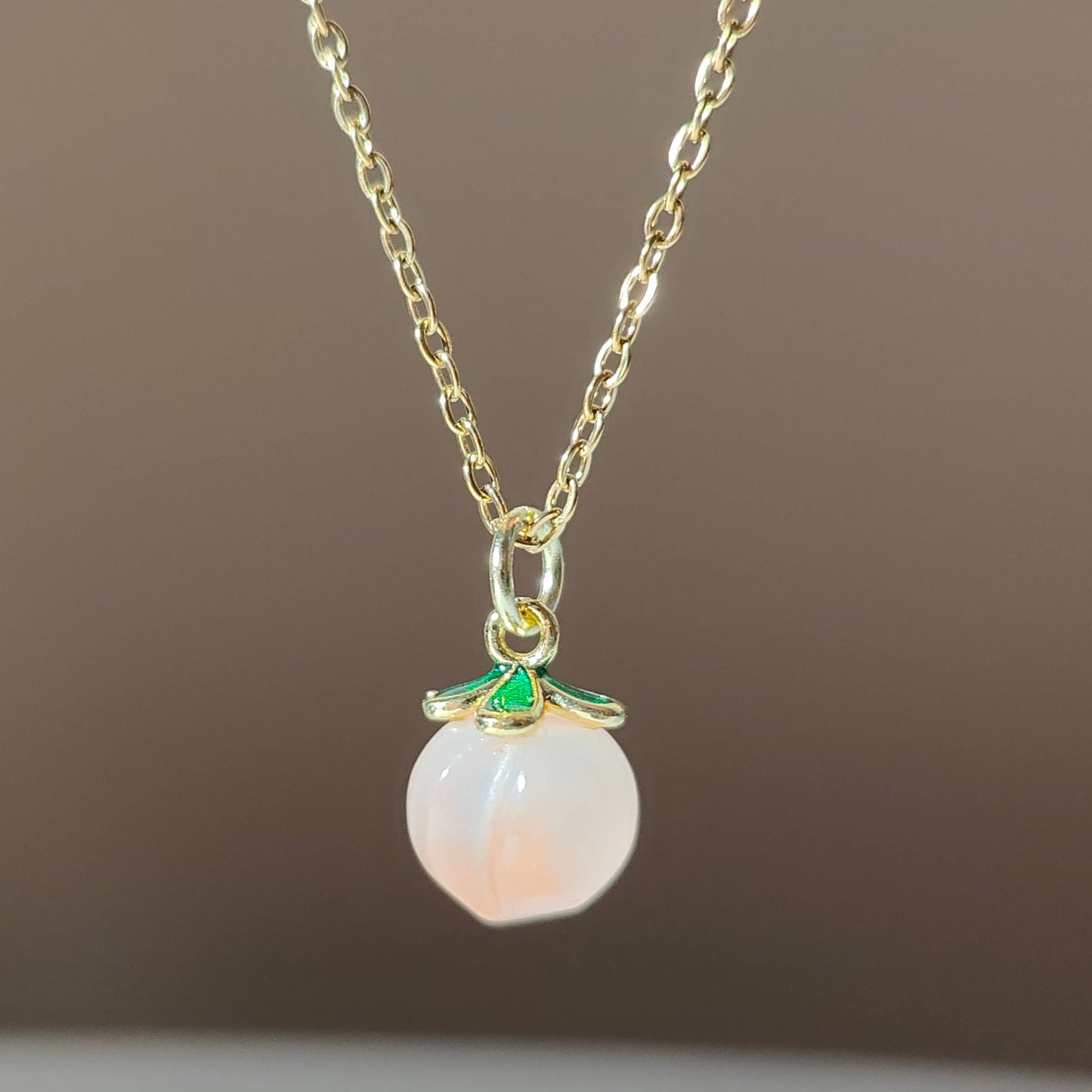 a natural yuan yan stone on a gold plate chain.