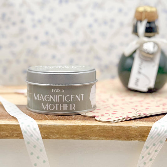 Tin labeled 'For a Magnificent Mother' on a wooden surface with decorative elements.