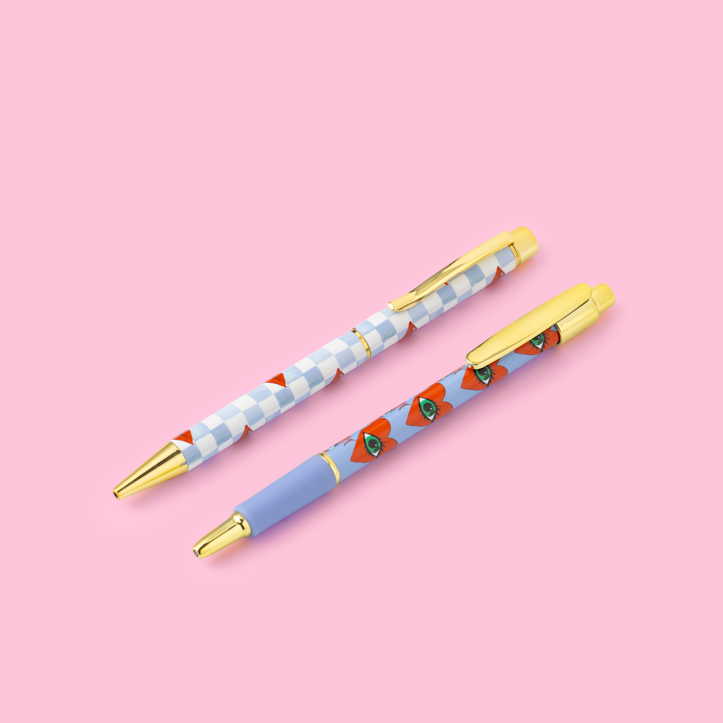 Two pens with floral designs on a pink background