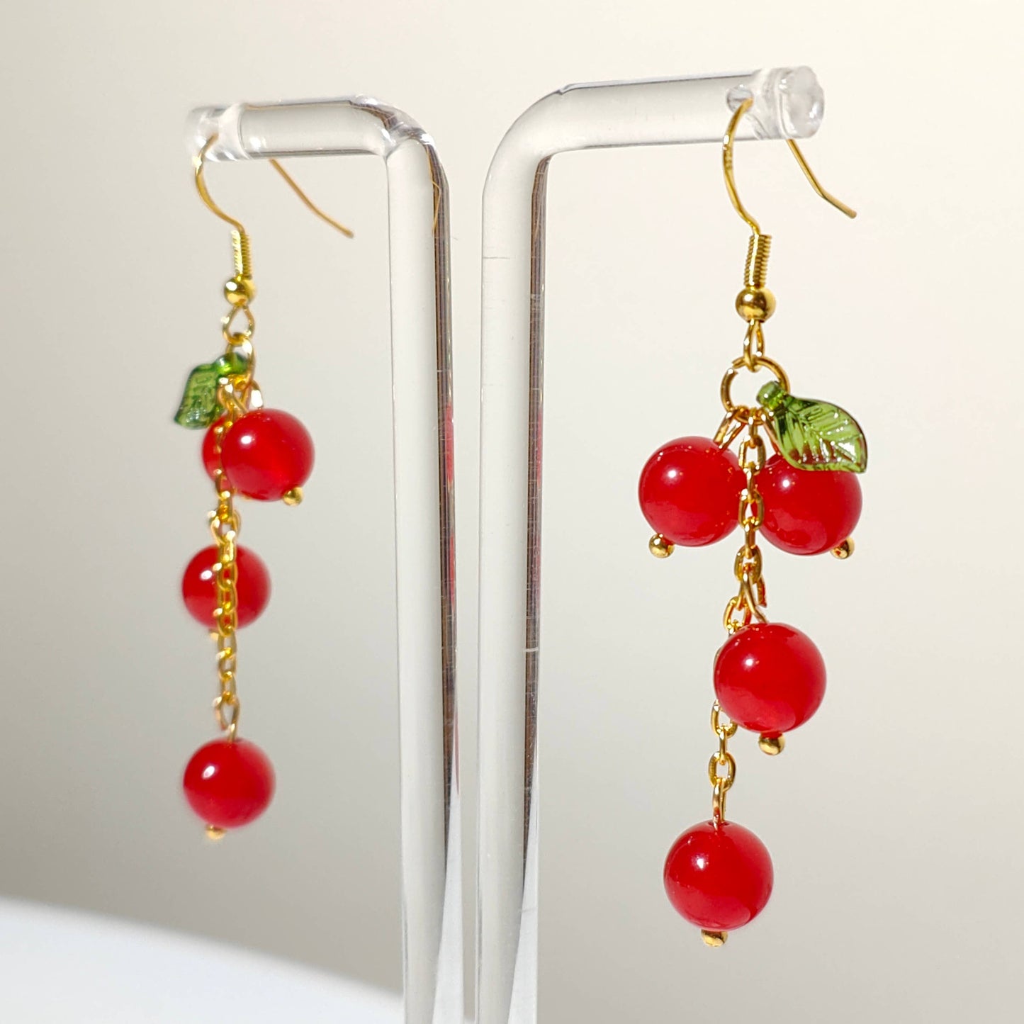 Cascade of red cherry gem stones with acrylic leaf on gold plated hooks