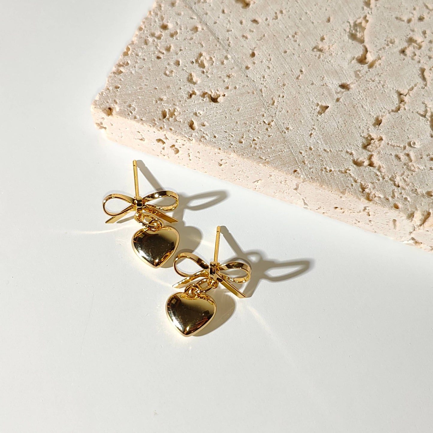Gold plate bow with dangling heart