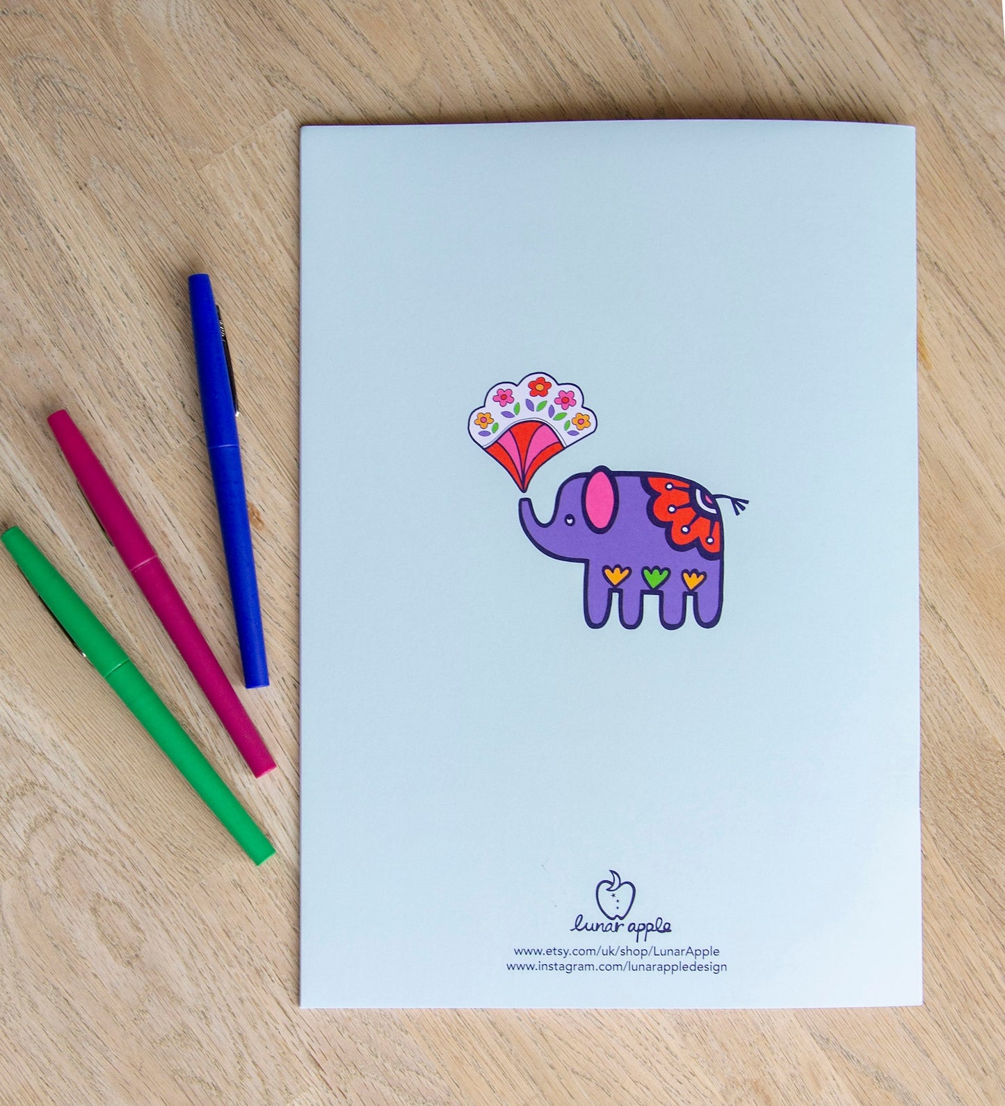 The back cover of a colouring book with a bright purple elephant in the centre.