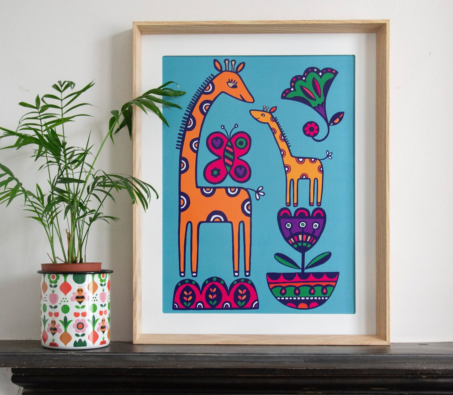 A colourful 2D illustration of a giraffe and baby giraffe surrounded by art deco flowers and large butterfly.
